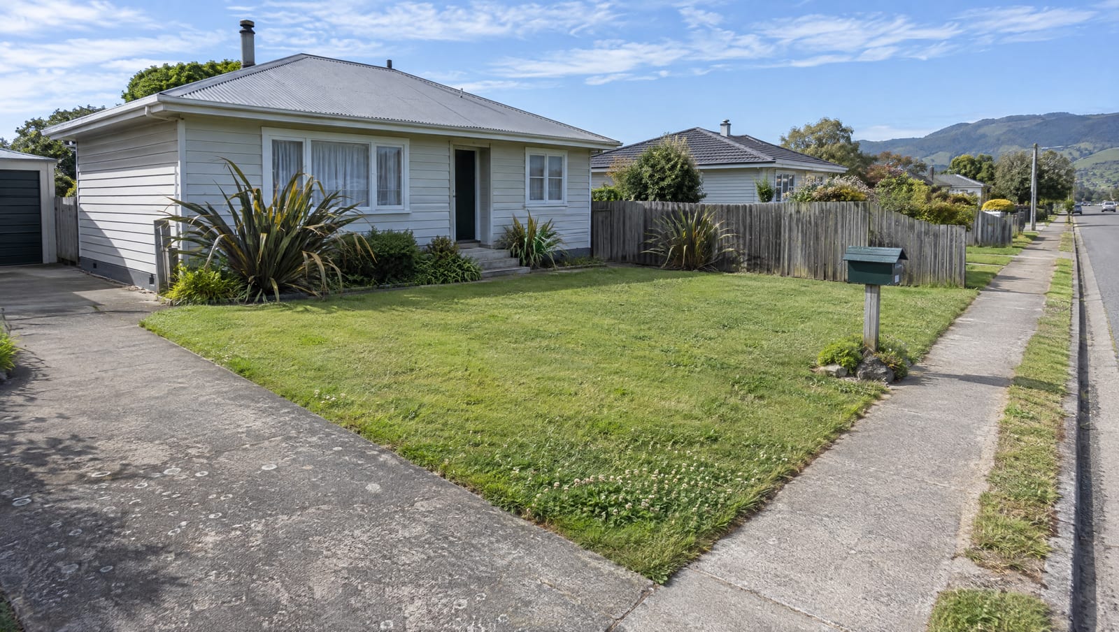 Freshly mown front lawn and crisp path edge outside a Kapiti Coast weatherboard house